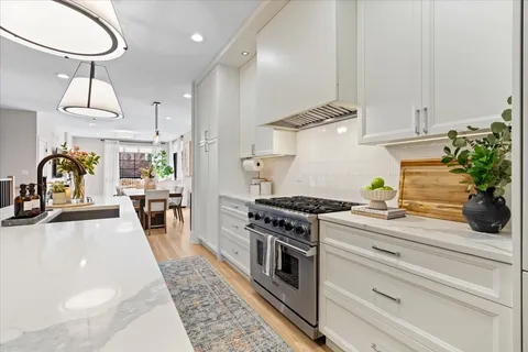 a kitchen with stainless steel appliances a sink stove and cabinets