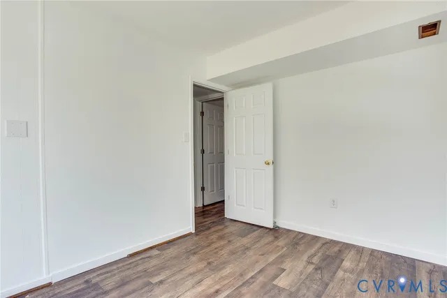 a view of an empty room and wooden floor
