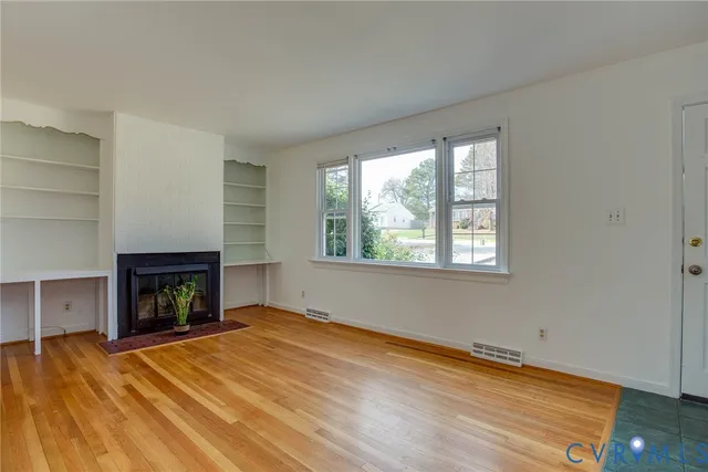 an empty room with a fireplace and window