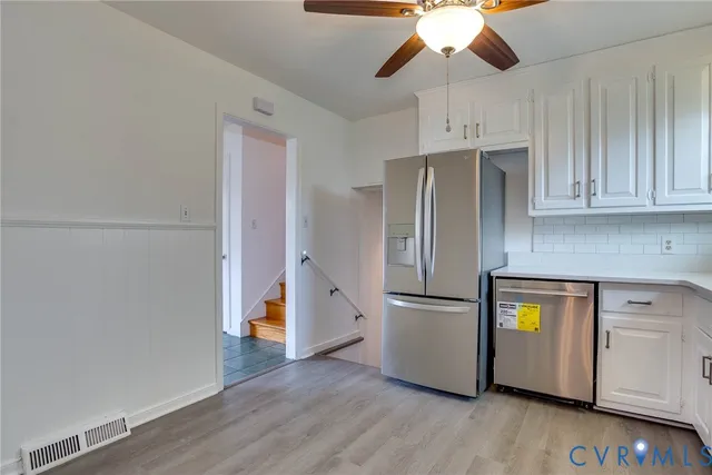 a kitchen with stainless steel appliances granite countertop a refrigerator and a stove top oven