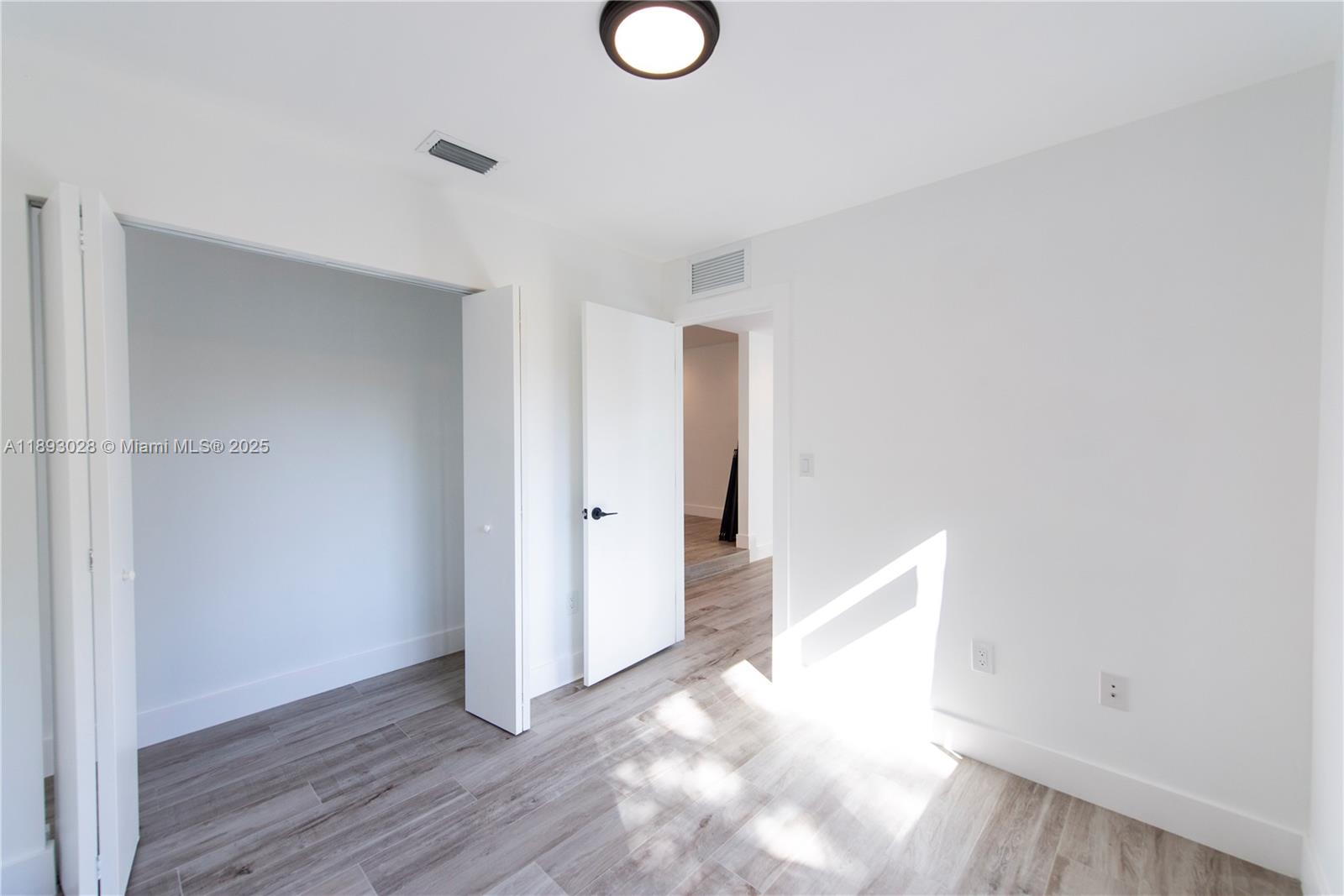 764 Northwest 36th Avenue, Unit 1 Miami, FL 33125 - Photo 4 of 17 a view of an empty room with wooden floor