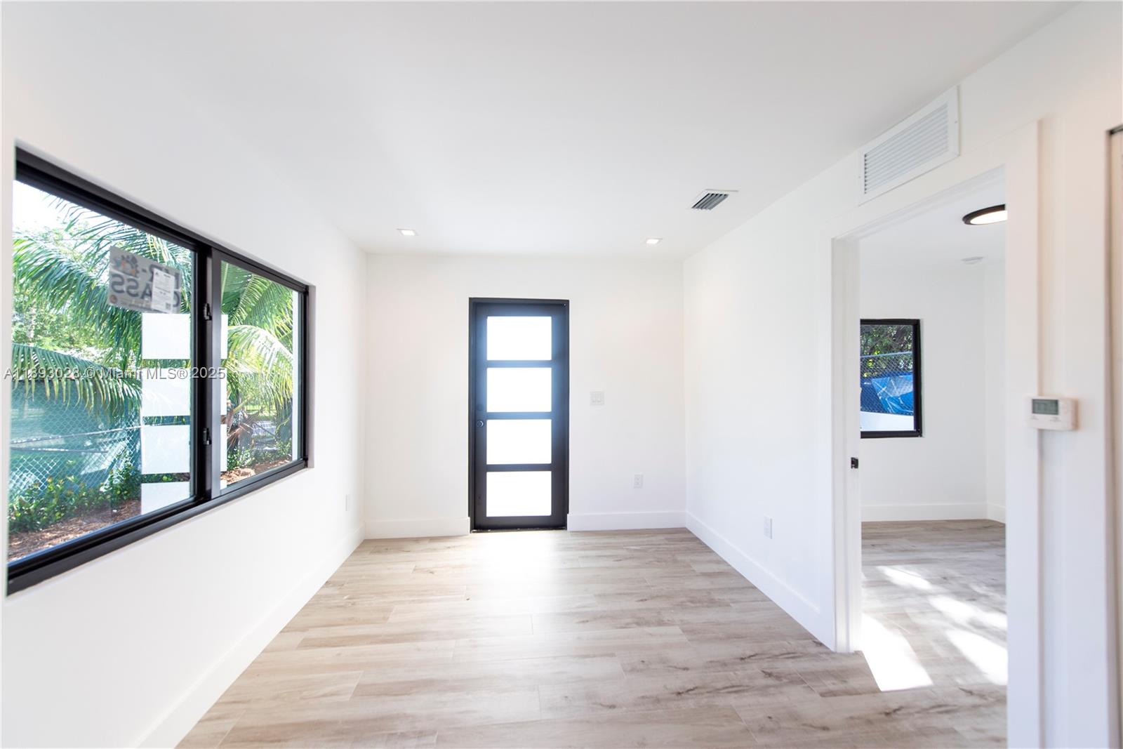 764 Northwest 36th Avenue, Unit 1 Miami, FL 33125 - Photo 7 of 17 wooden floor in an empty room with a window