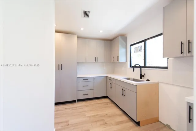 a kitchen with sink cabinets and window