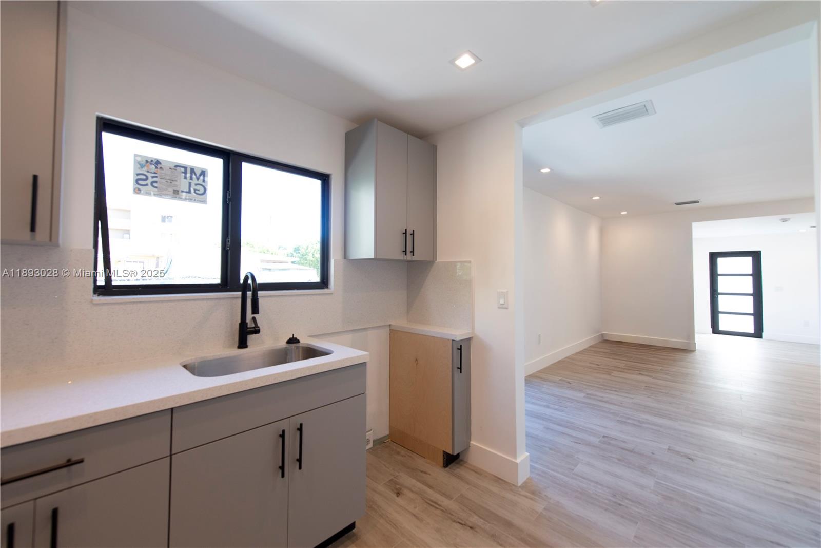 764 Northwest 36th Avenue, Unit 1 Miami, FL 33125 - Photo 9 of 17 a kitchen with a sink cabinets and wooden floor