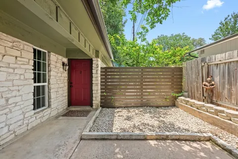 a front view of house with yard and trees in the background