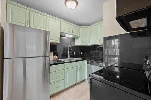 a kitchen with stainless steel appliances a refrigerator sink and cabinets