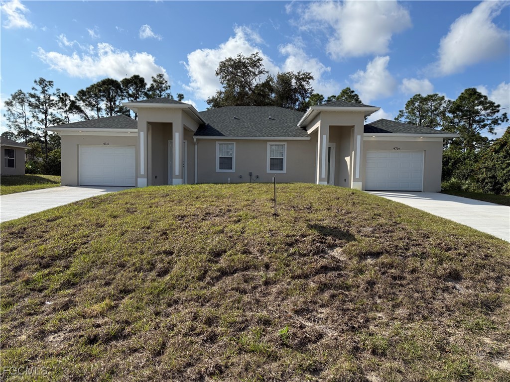 a front view of a house with a yard and a garage