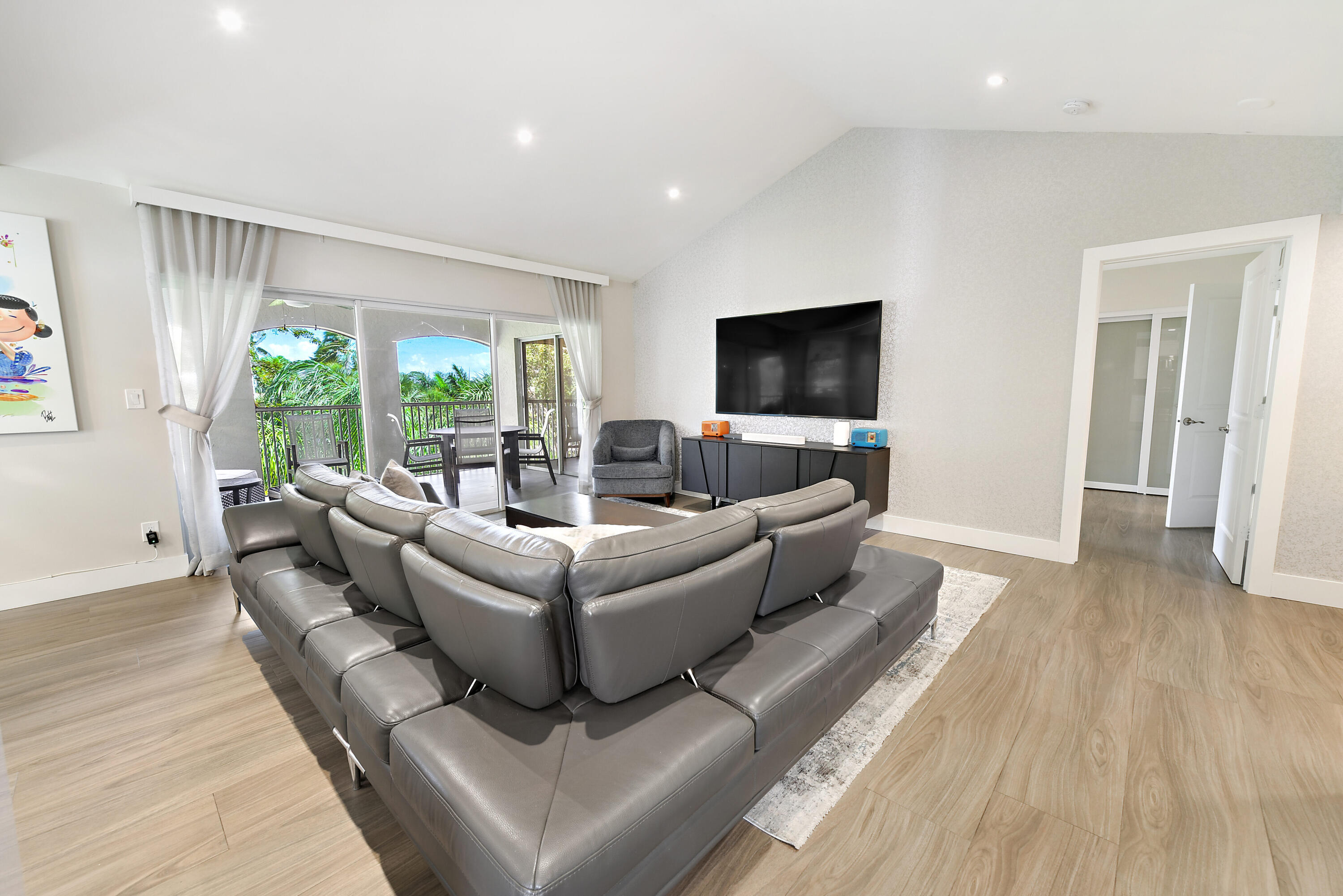 7369 Orangewood Lane, Unit 301 Boca Raton, FL 33433 - Photo 11 of 53 a living room with furniture and a flat screen tv