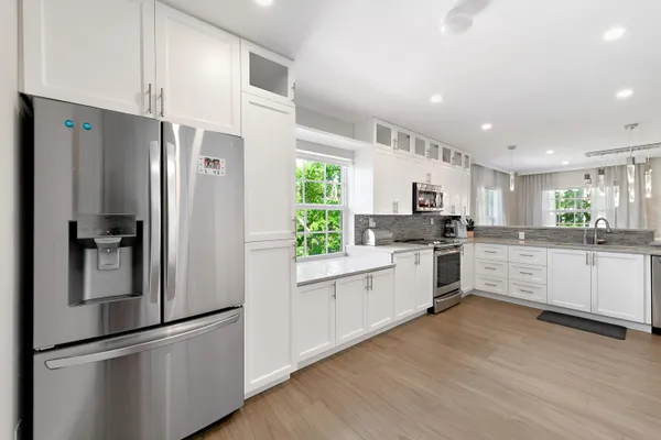 a kitchen with white cabinets and stainless steel appliances