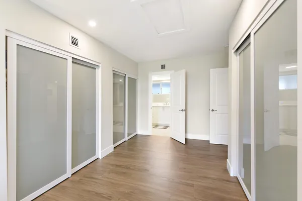 a view of empty room with wooden floor