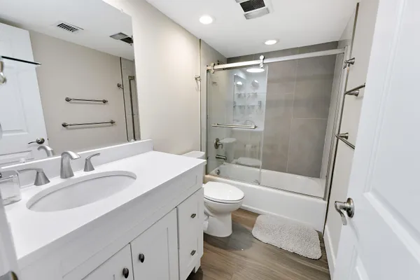 a bathroom with a sink a toilet and shower