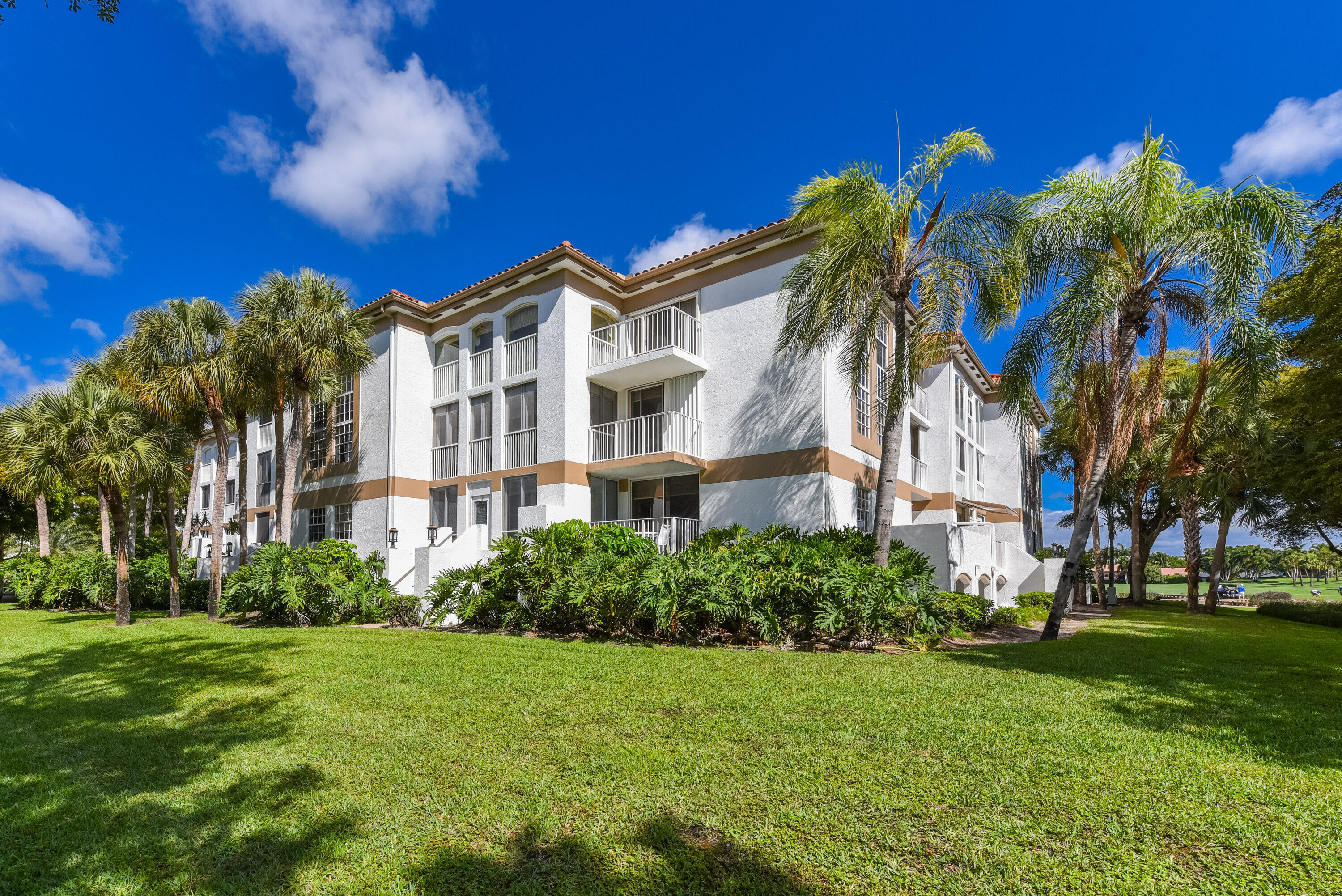 7369 Orangewood Lane, Unit 301 Boca Raton, FL 33433 - Photo 4 of 53 a front view of a multi story residential apartment building with yard and green space