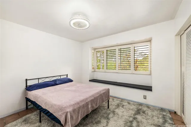 a bed sitting in a bedroom next to a window