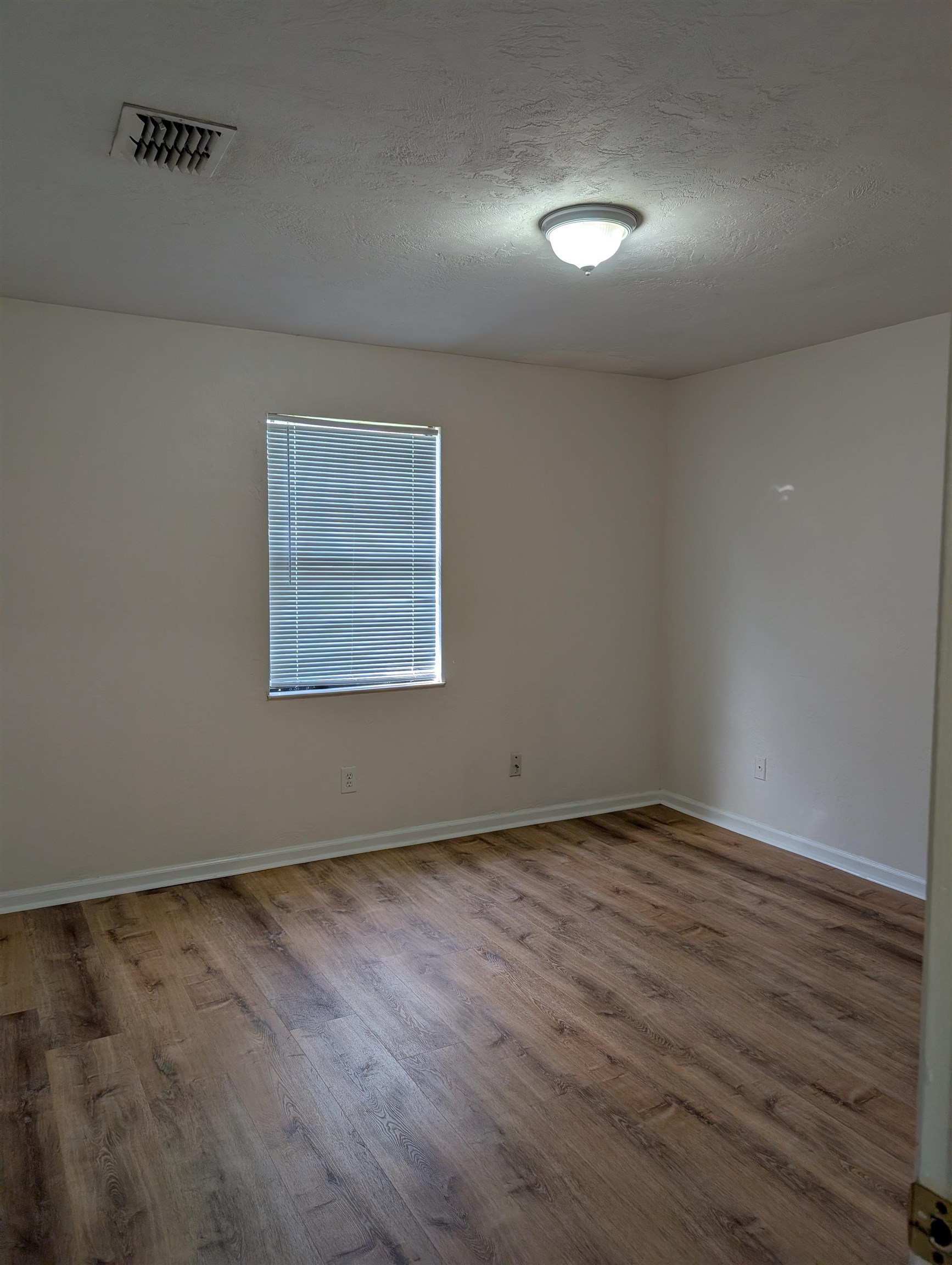 3891 Osprey Circle, Unit B St. Augustine, FL 32086 - Photo 17 of 18 an empty room with wooden floor and windows