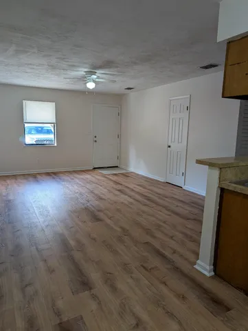 a view of empty room with wooden floor