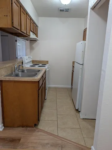 a kitchen with a sink a refrigerator and cabinets