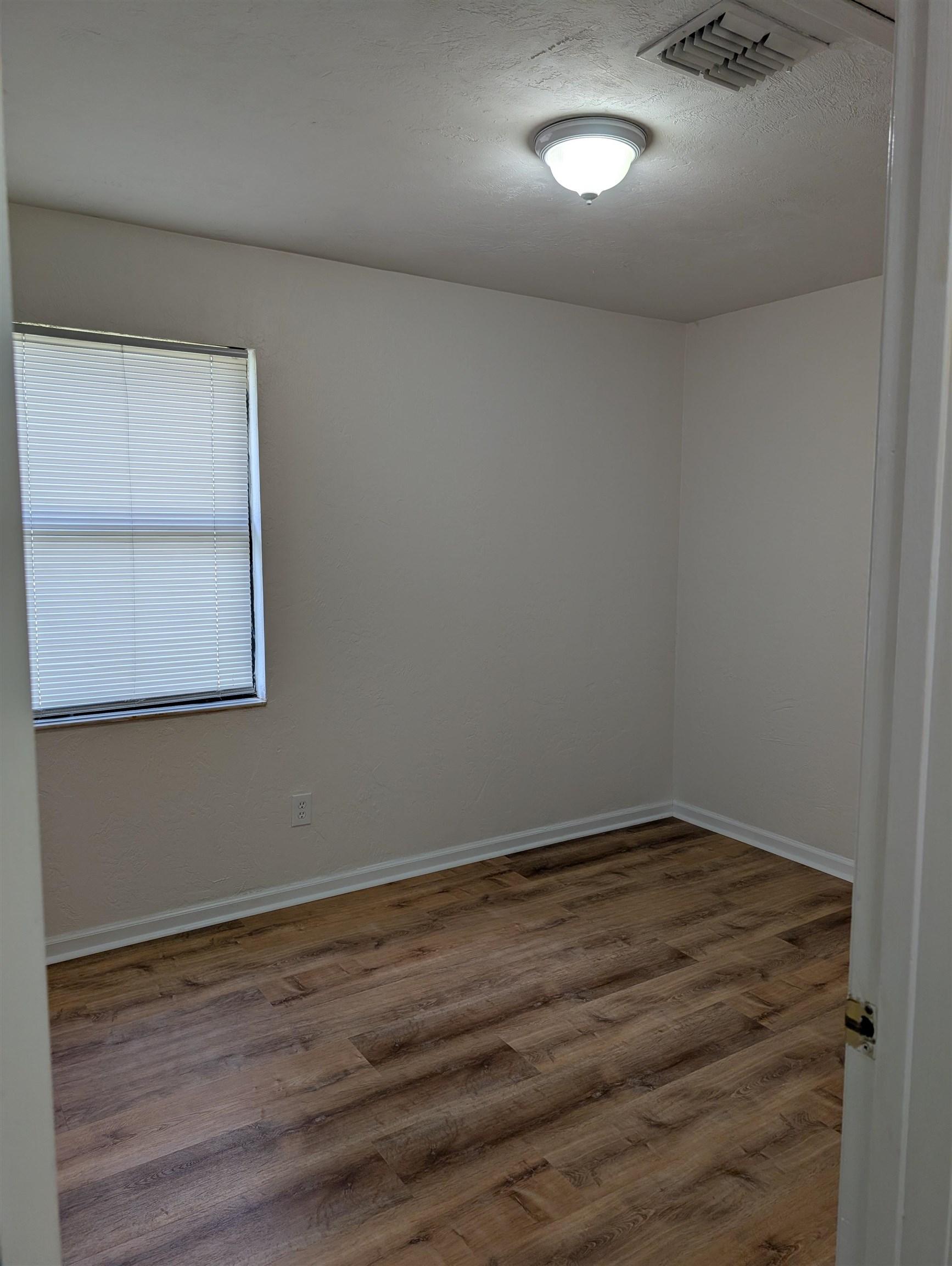 3891 Osprey Circle, Unit B St. Augustine, FL 32086 - Photo 10 of 18 an empty room with wooden floor and windows