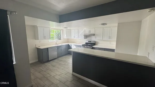 a kitchen with stainless steel appliances a sink stove and cabinets