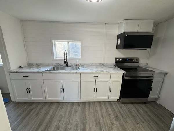 a kitchen with stainless steel appliances granite countertop a stove a sink and a microwave