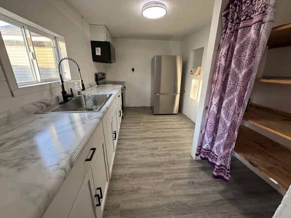 a hallway with a stove a sink and a refrigerator