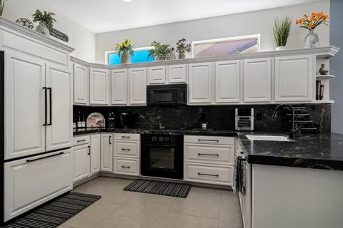 a kitchen with stainless steel appliances granite countertop a refrigerator and a stove top oven