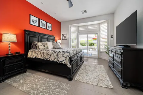 a bed room with a bed tv and a window