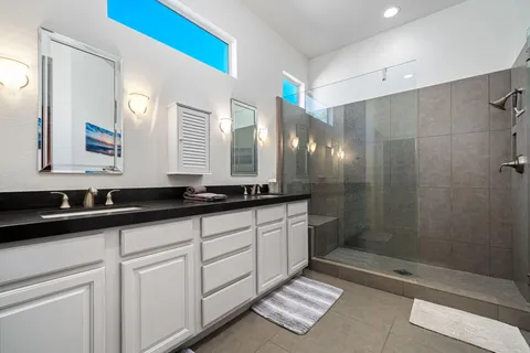 a bathroom with double sink and a mirror