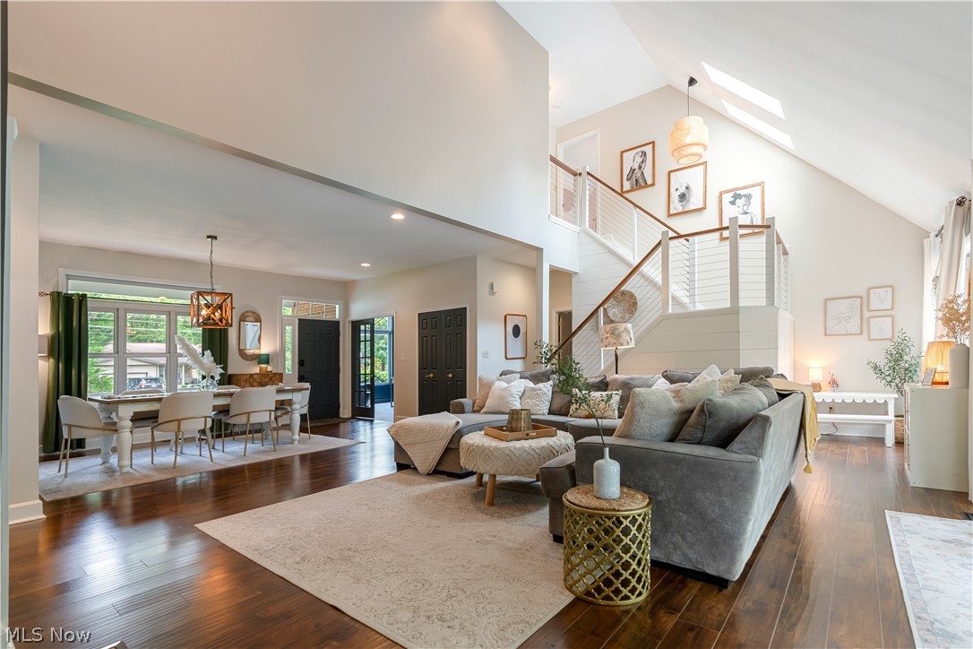 3228 Bancroft Road Akron, OH 44333 - Photo 20 of 50 Living room with dark hardwood / wood-style floors, high vaulted ceiling, an inviting chandelier, and a skylight