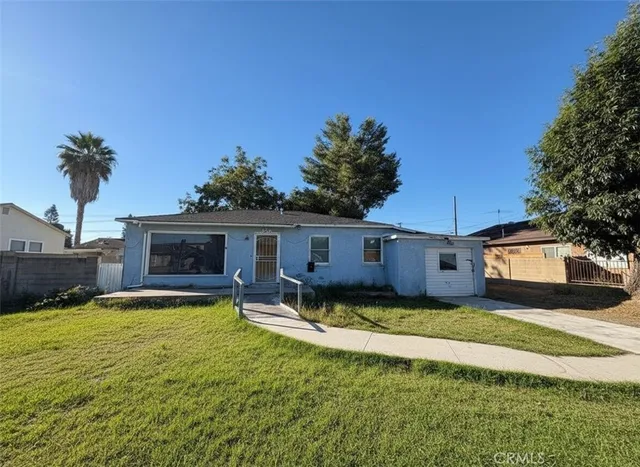 a view of a house with a yard patio and fire pit