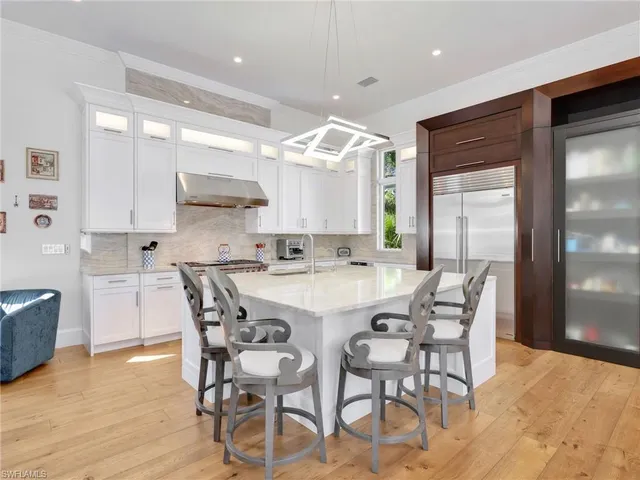 a kitchen with kitchen island a dining table and chairs