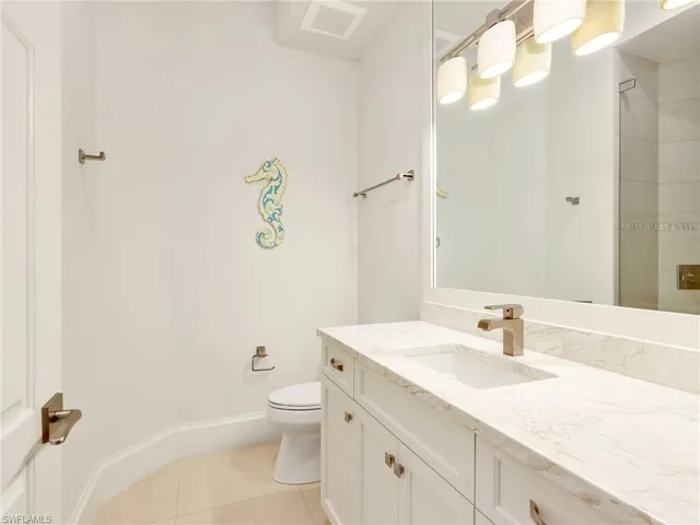 a bathroom with a granite countertop sink a toilet and a mirror