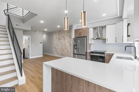 a kitchen with stainless steel appliances kitchen island granite countertop a sink a refrigerator and a stove