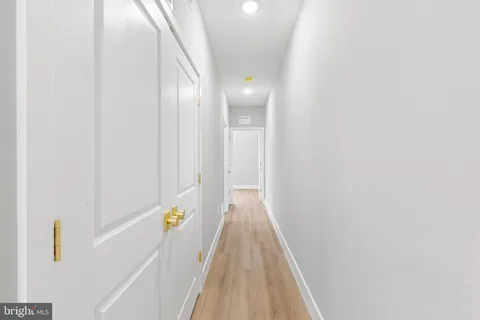 a view of a hallway with wooden floor and stairs
