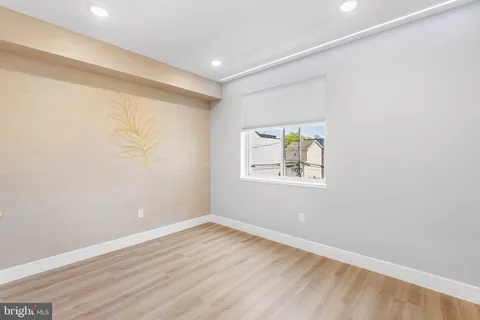 an empty room with wooden floor and window