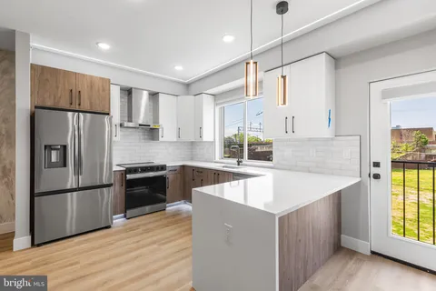 a kitchen with stainless steel appliances granite countertop a refrigerator a sink dishwasher a stove and a refrigerator