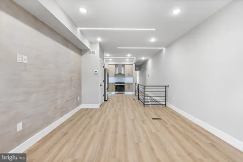 a view of empty room with wooden floor and fireplace