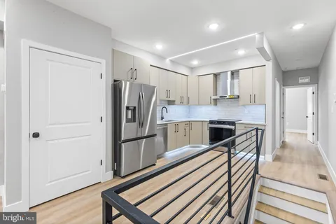 a kitchen with stainless steel appliances a refrigerator and a stove top oven