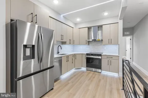 a kitchen with granite countertop stainless steel appliances a refrigerator and cabinets