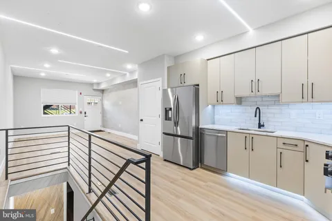 a kitchen with refrigerator cabinets and wooden floor