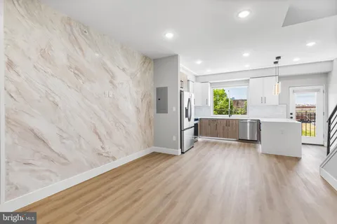 a view of a big room with wooden floor and windows