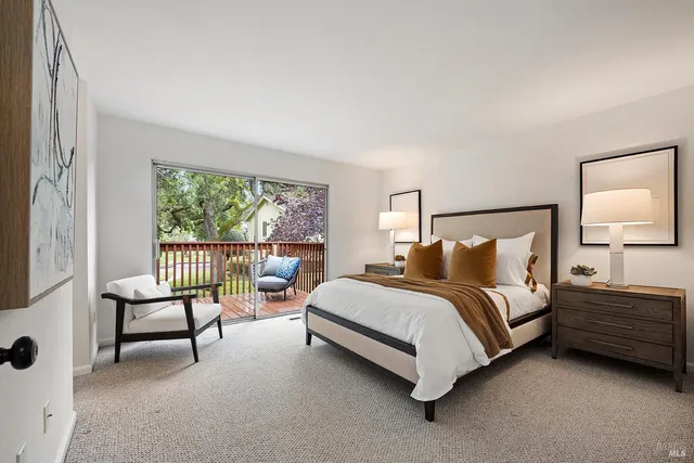 a spacious bedroom with a bed chair and window