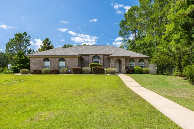 a front view of a house with yard and green space