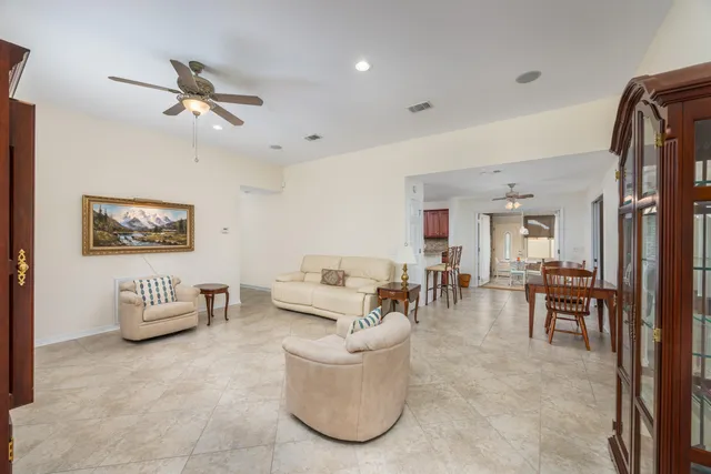 a living room with furniture and a dining table with wooden floor