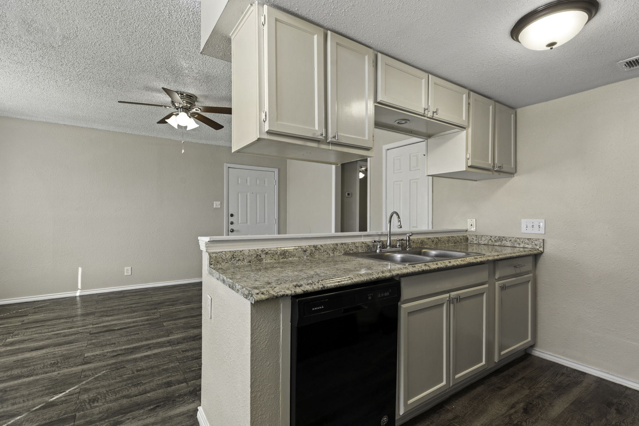 6110 Wheless Cove, Unit F Austin, TX 78723 - Photo 3 of 12 Kitchen with dishwasher, a ceiling fan, a textured ceiling, gray cabinets, and dark wood finished floors