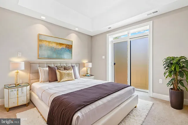 a spacious bedroom with a large bed and a potted plant