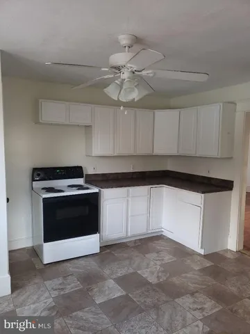 a kitchen with a stove and white cabinets