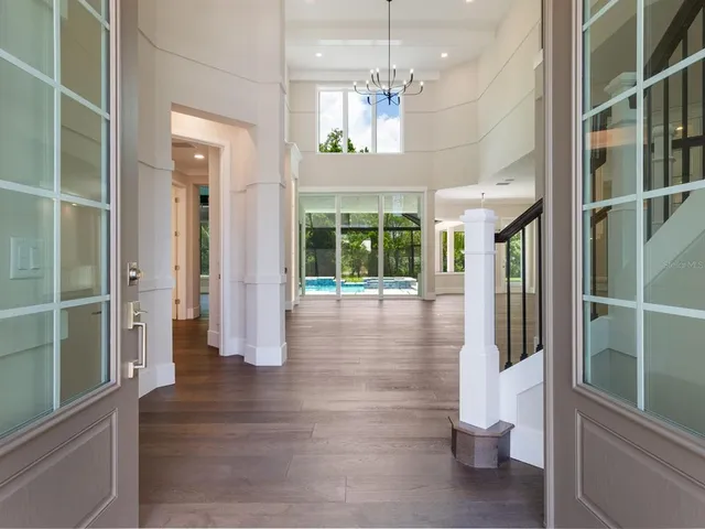 a view of a hallway with wooden floor and a bathroom