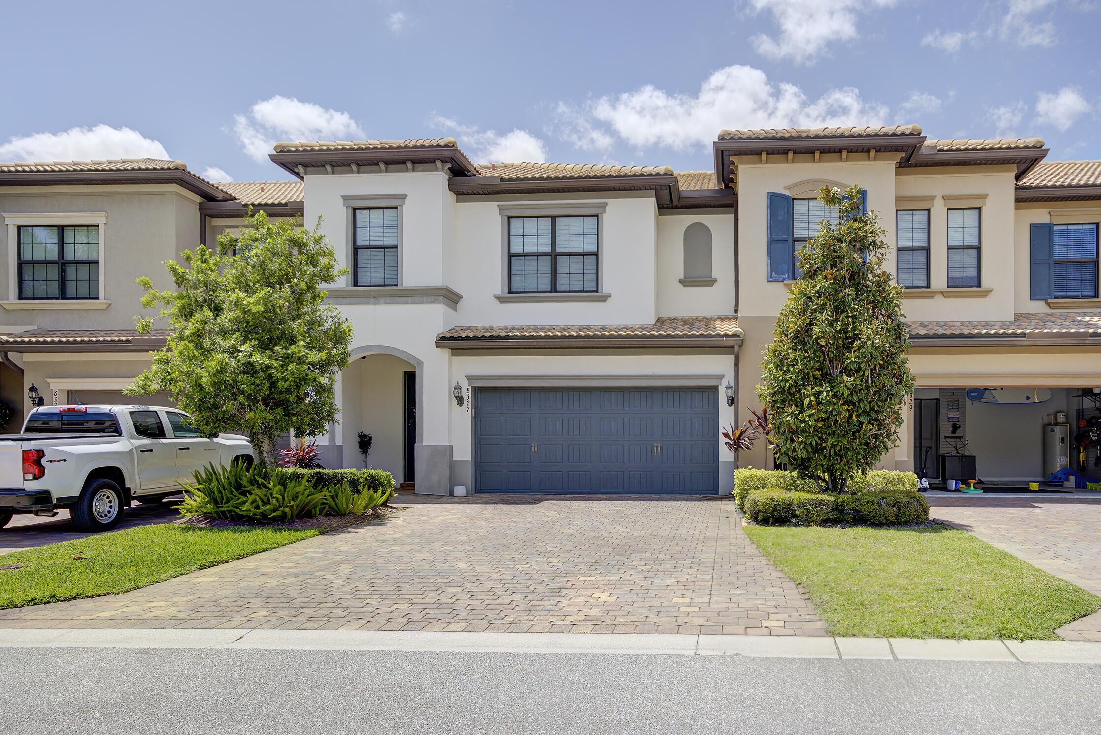 8327 Rearing Lane Lake Worth, FL 33467 - Photo 2 of 31 a front view of a house with a garden and garage