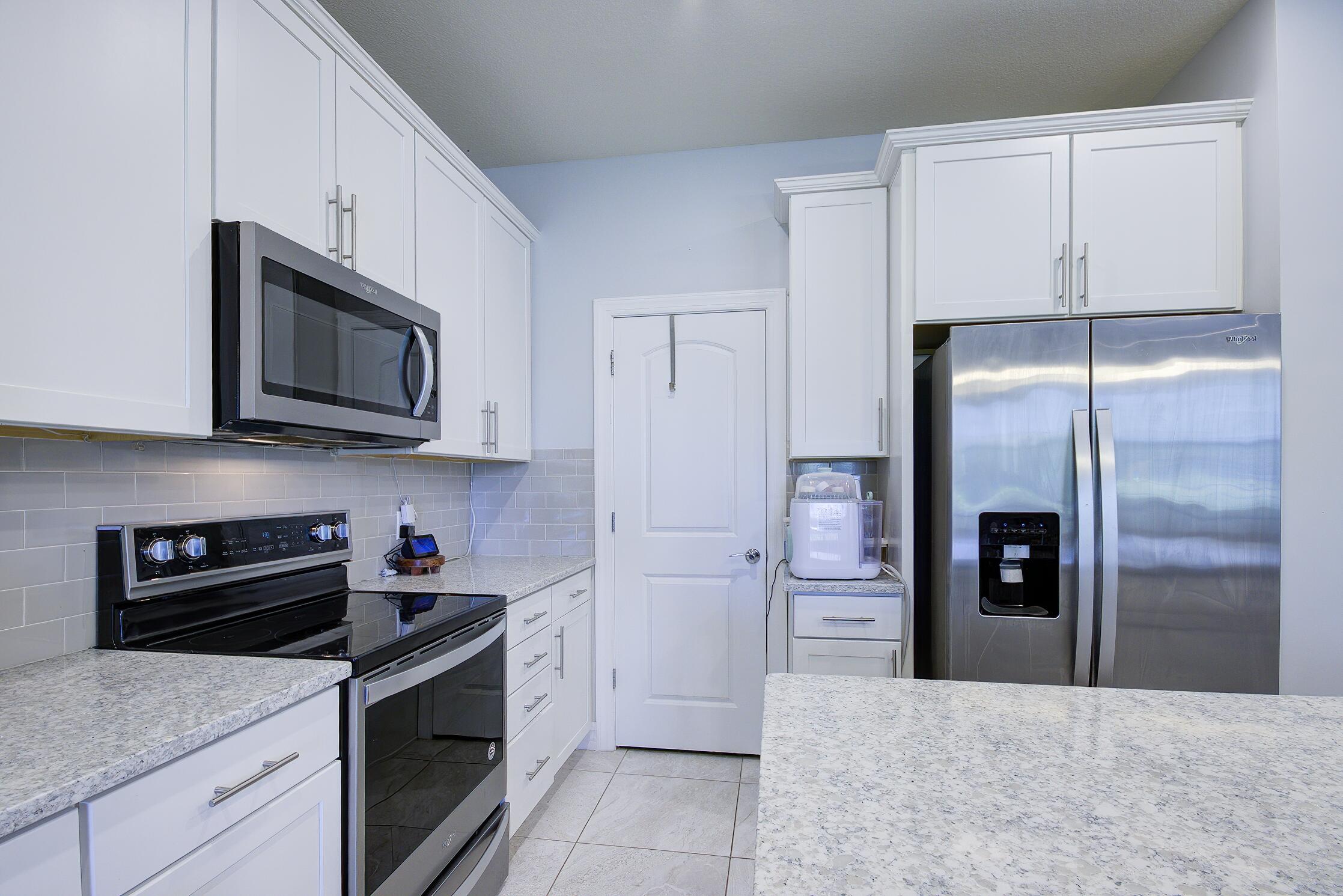 8327 Rearing Lane Lake Worth, FL 33467 - Photo 8 of 31 a kitchen with stainless steel appliances granite countertop a refrigerator and a stove top oven