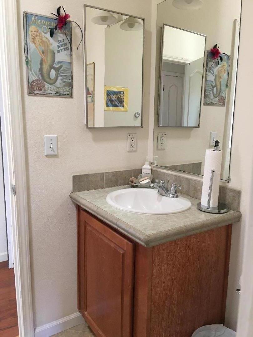 580 Russell Ridge Watsonville, CA 95076 - Photo 43 of 50 a bathroom with a granite countertop sink a mirror and vanity